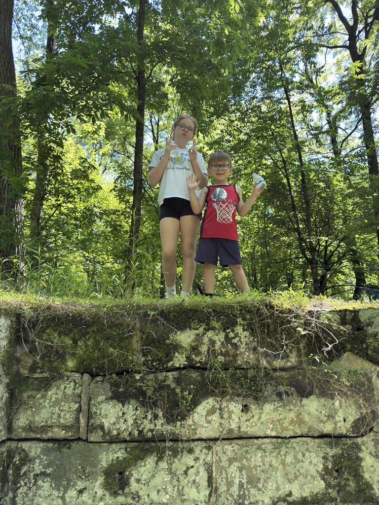 Sophia and Raiden standing on rocks at the park