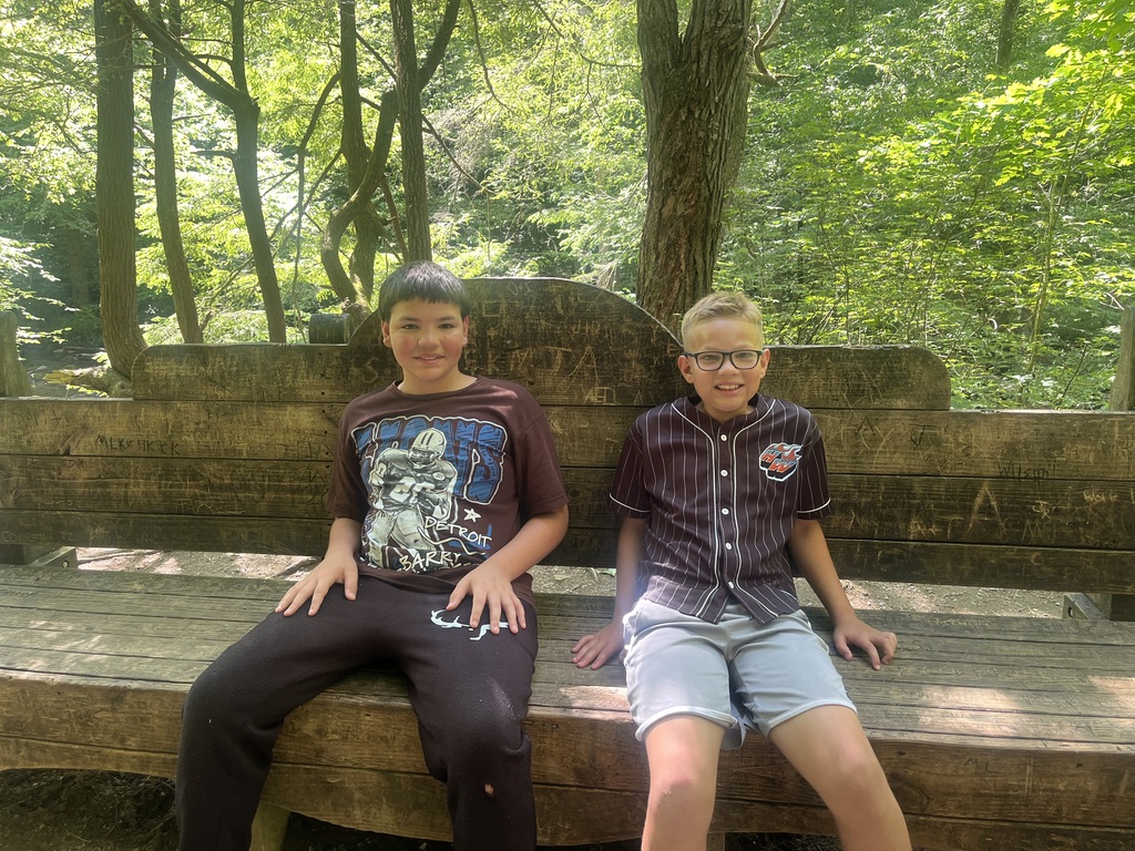 Jaydan and Chris sitting on a bench in the woods