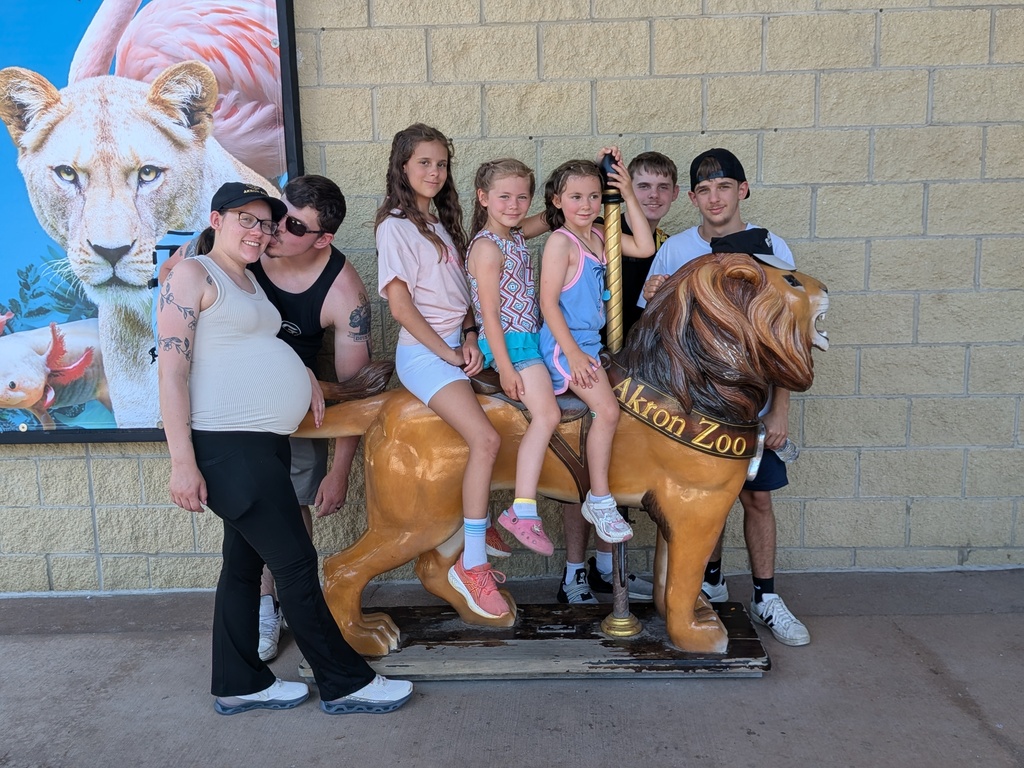 Family picture with the kids sitting on a lion statue