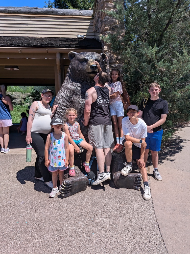 family picture in front of a giant bear statue