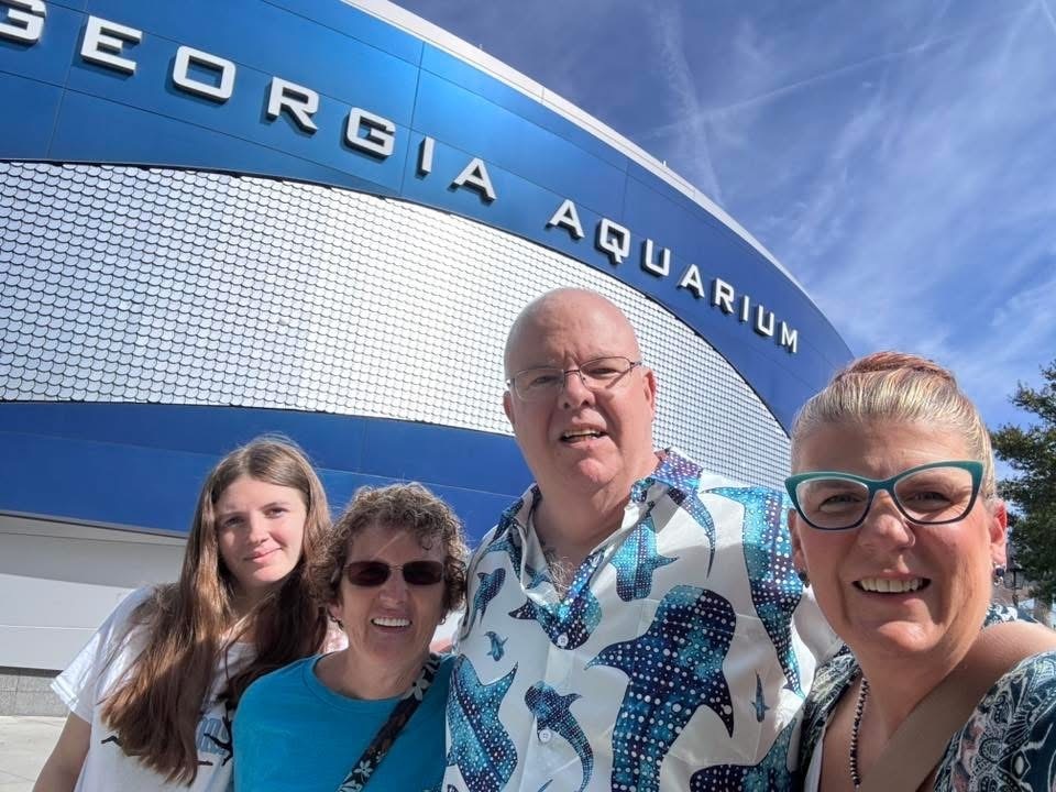 Shyanne standing with her family in front of the aquarium
