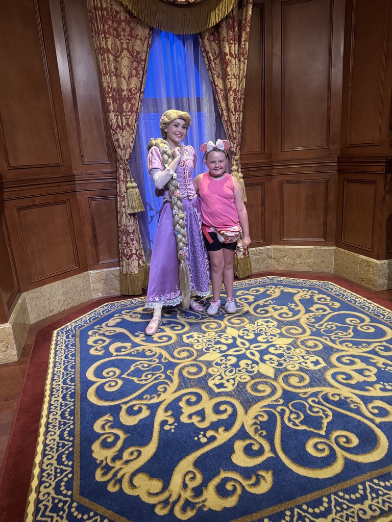 Julie standing with Rapunzel at Disney