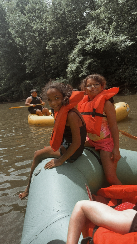 two kids smiling while wearing lifejackets