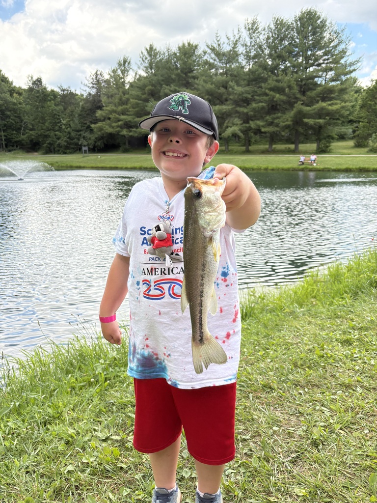 Student holding a bass that he caught while fishing