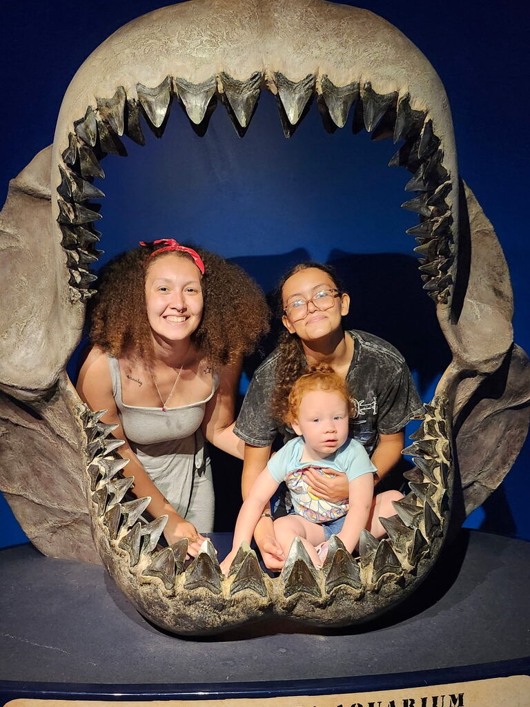 Taci & Mila standing in the fossilized jaw of a shark