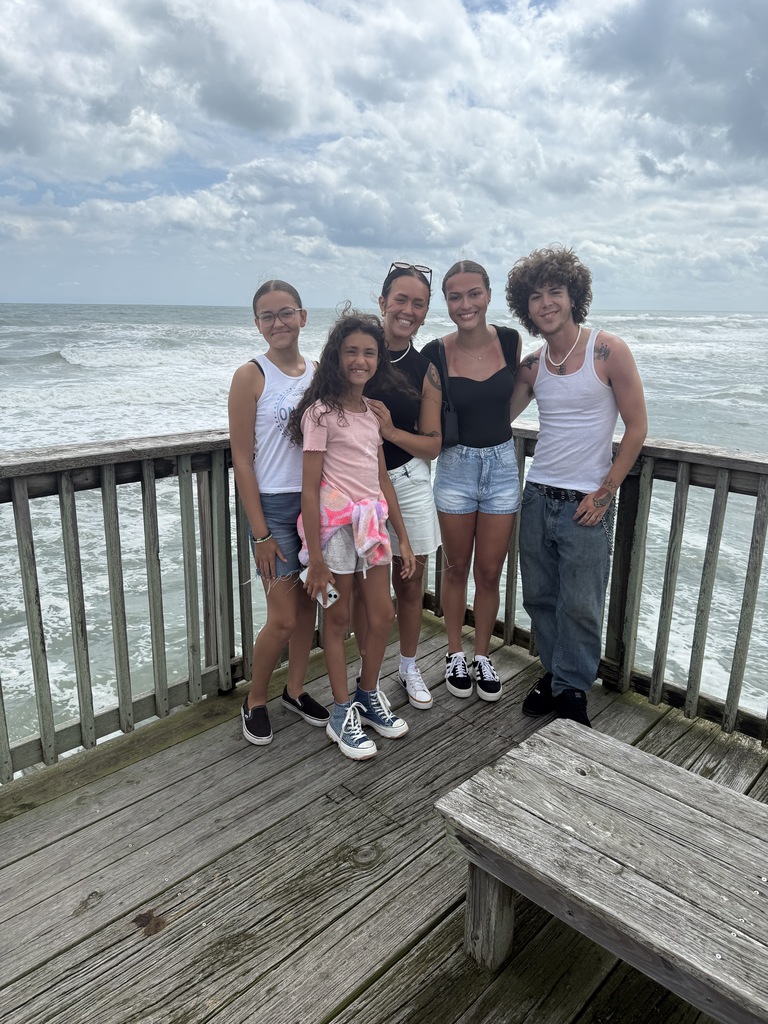 the family standing on a pier with the ocean in the background