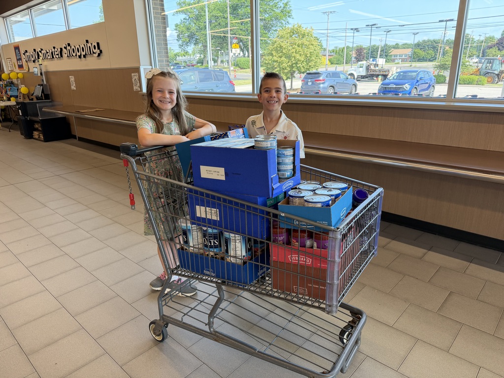 Cora and Henry standing with a cart full of items they donated