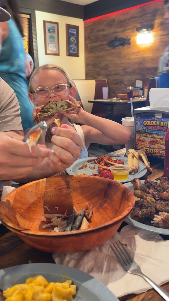 a student holding a crab at a seafood restaurant