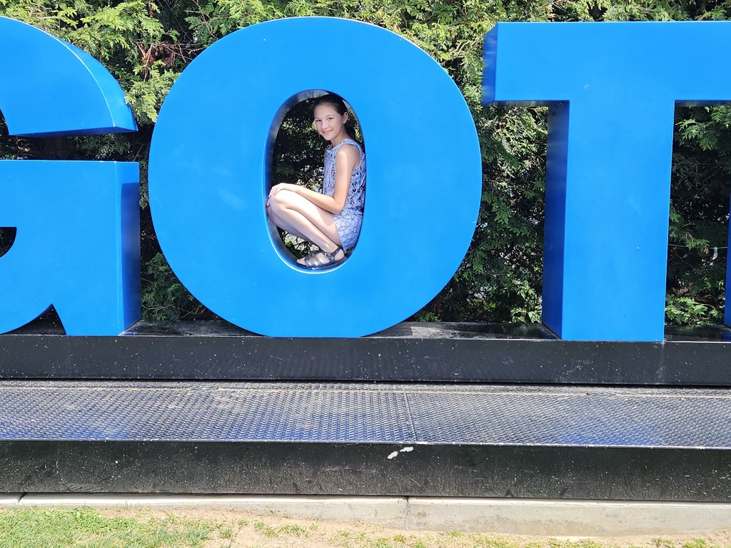 Ava sitting in the "o" of the GOTL sign