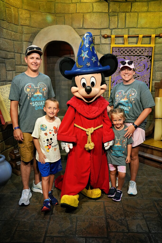 The Gibson family standing with sorcerer mickey