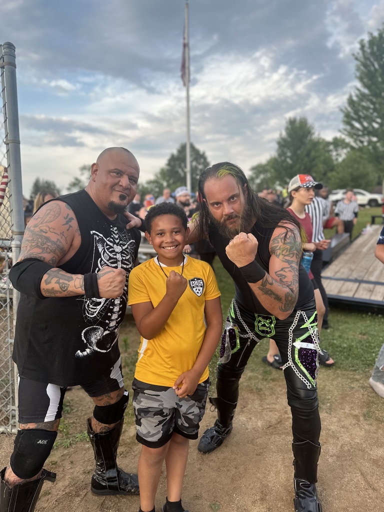 Liam posing with two wrestlers at the 250th celebration