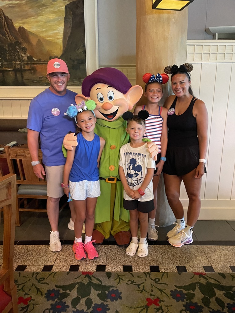The Ganni family standing next to Dopey, one of the seven dwarfs