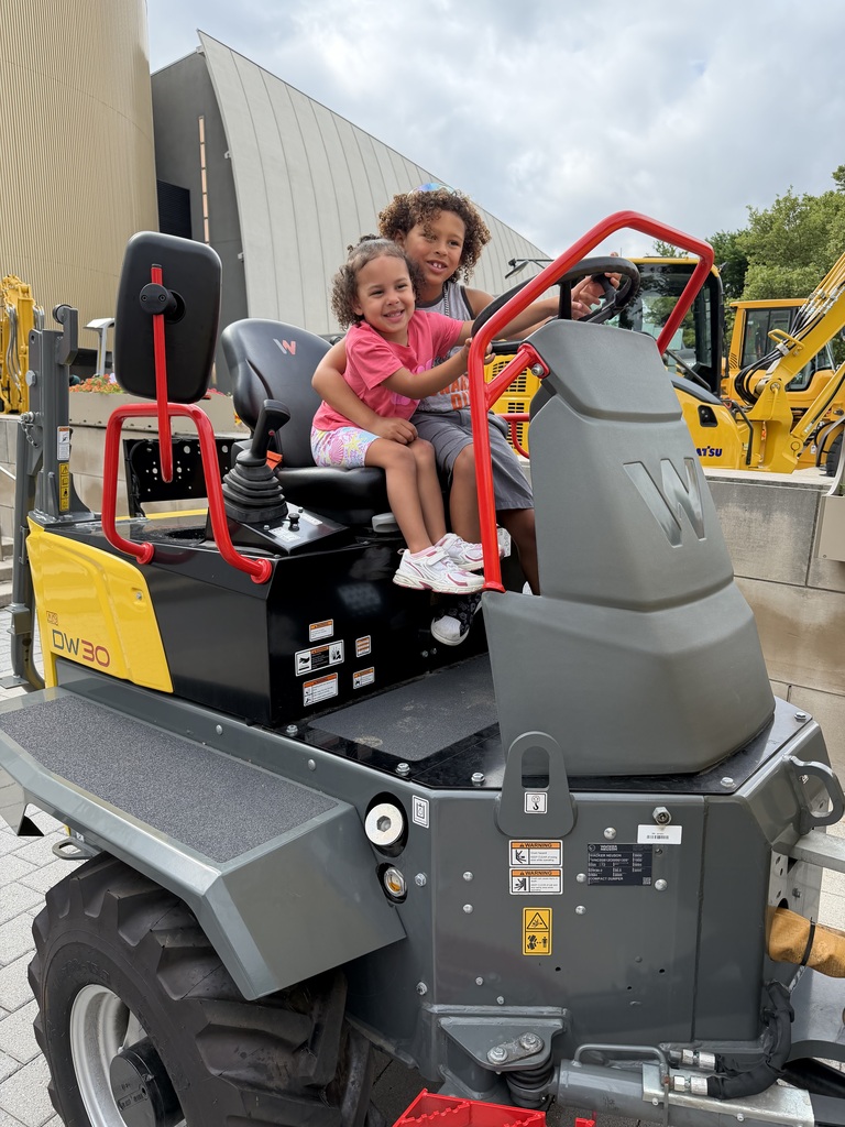 Taiden and Taleah sitting on a big maching