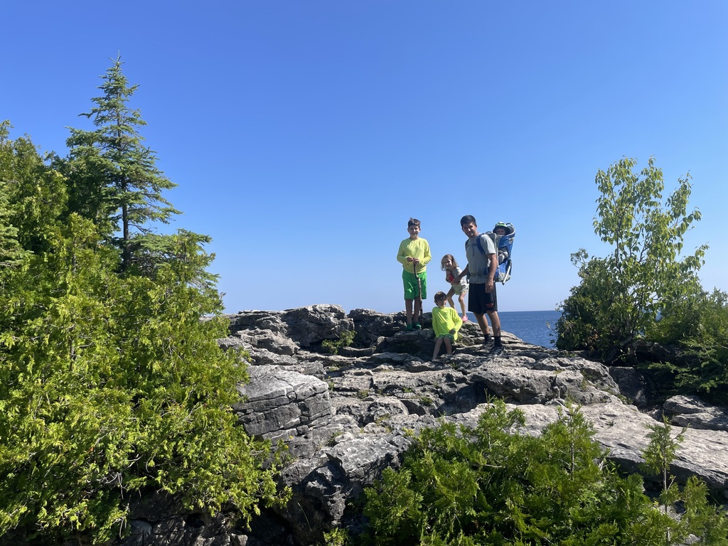 the kids standing on some stones during a hike.