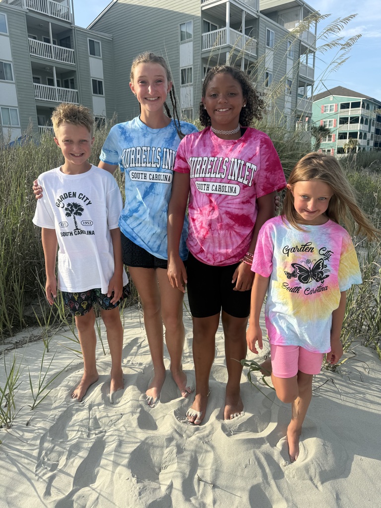 the kids standing on the beach with condos in the background