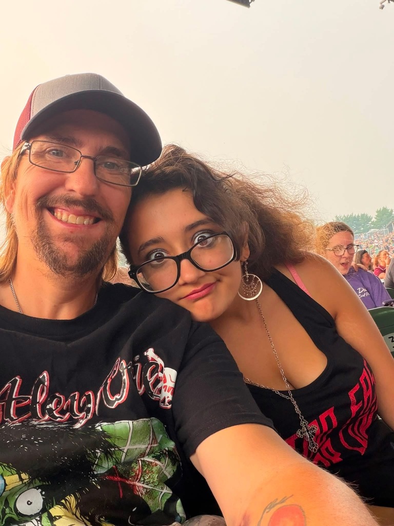 Aubree and her dad posing for a picture at the concer