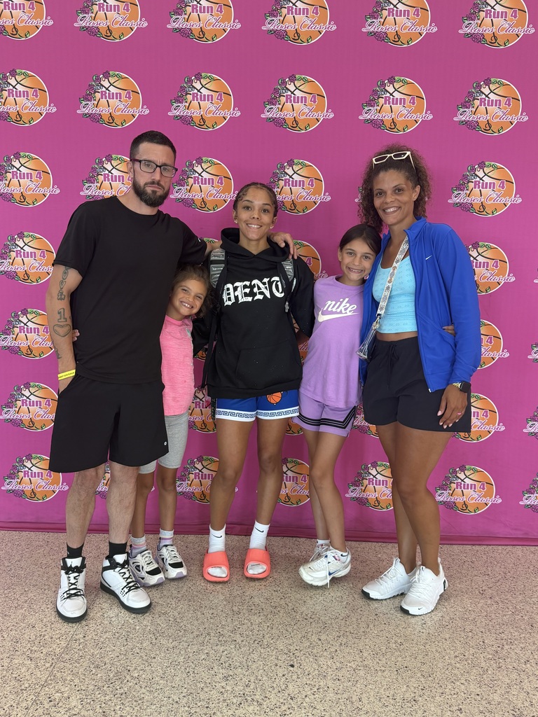 the lundsford family standing in front of a pink backdrop with basketballs all over it.