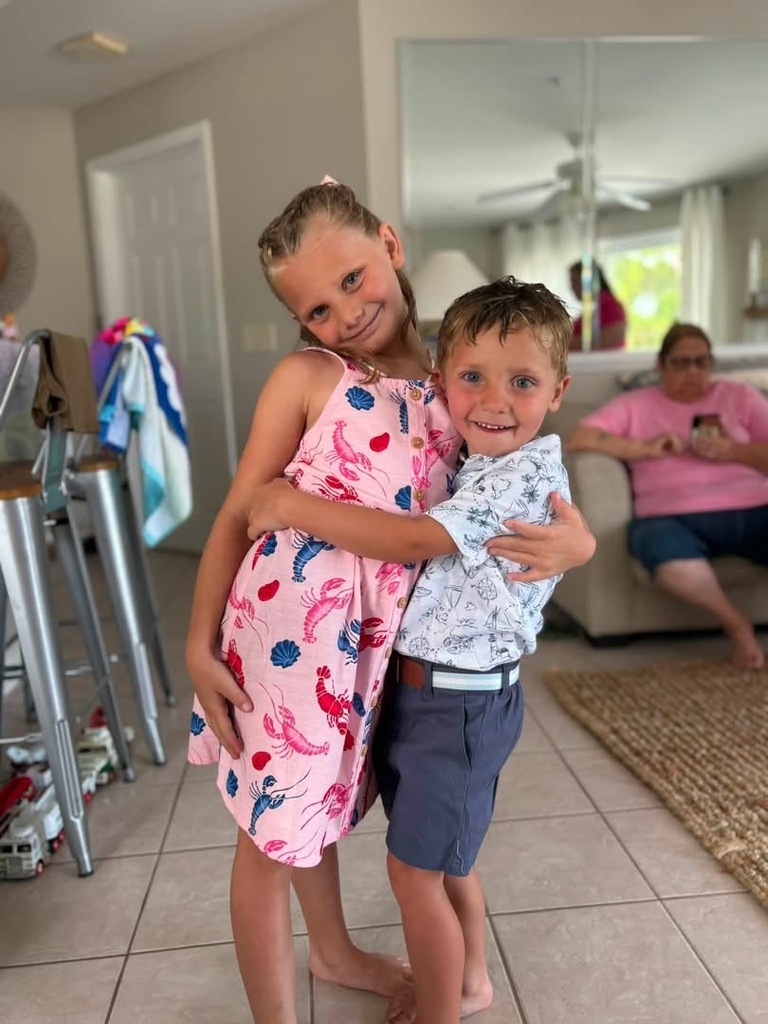 Gracie hugging another kid what what appears to be a living room