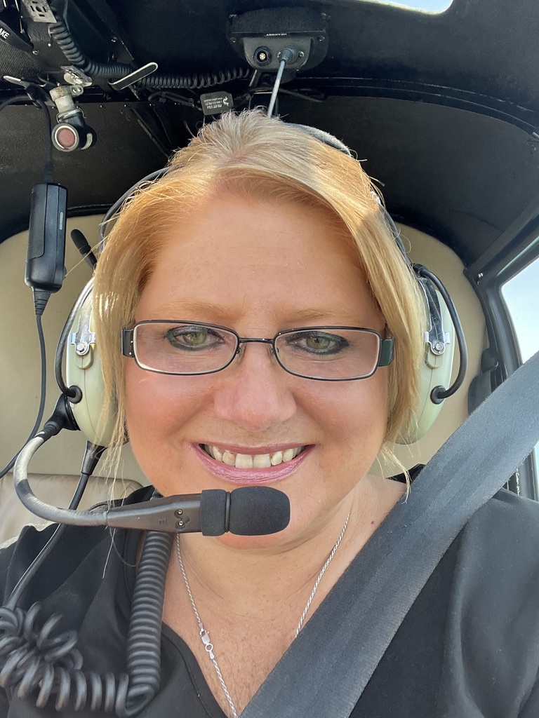 Kelly sitting in the helicopter with the headset on