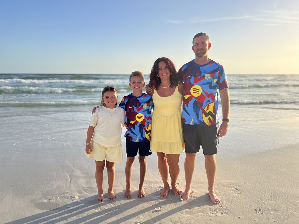 Morrison family standing on the beach at sunset. 