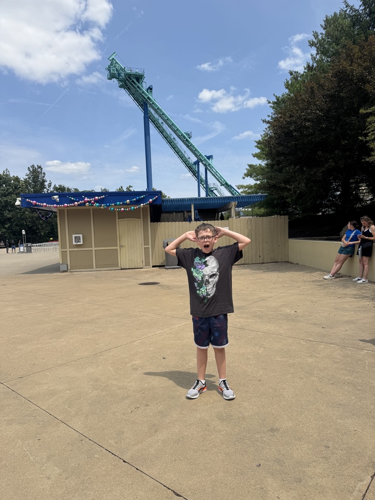 Jayce standing in front of a roller coaster 