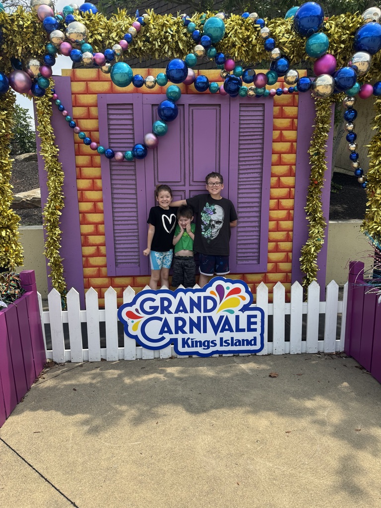 Kids standing in front of a door with the sign Grand Carnivale Kings Island