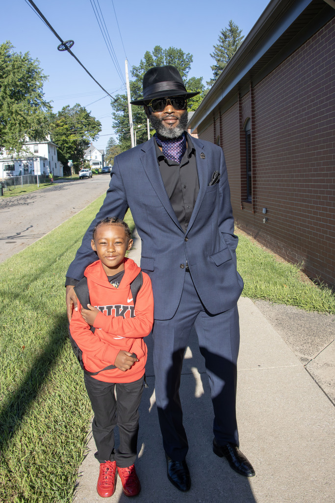 A father standing next to his child before entering school