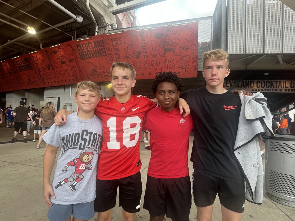 Picture of 4 students standing in front of a cleveland browns banner smiling