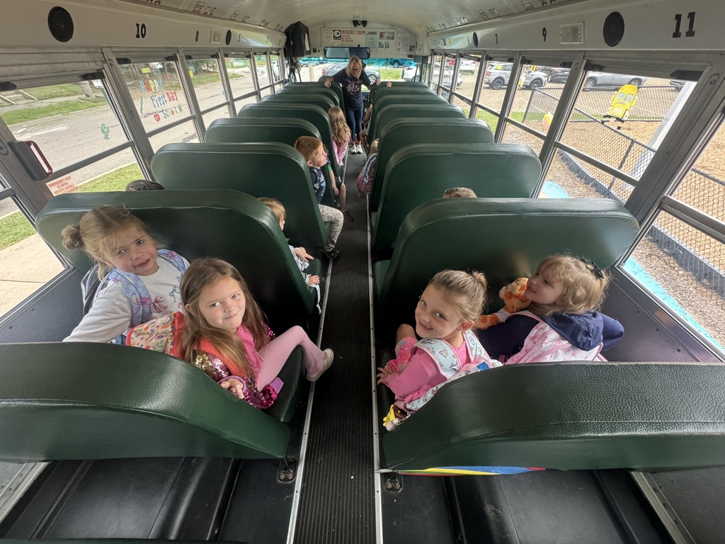 Charleigh and three other girls smile while riding the bus