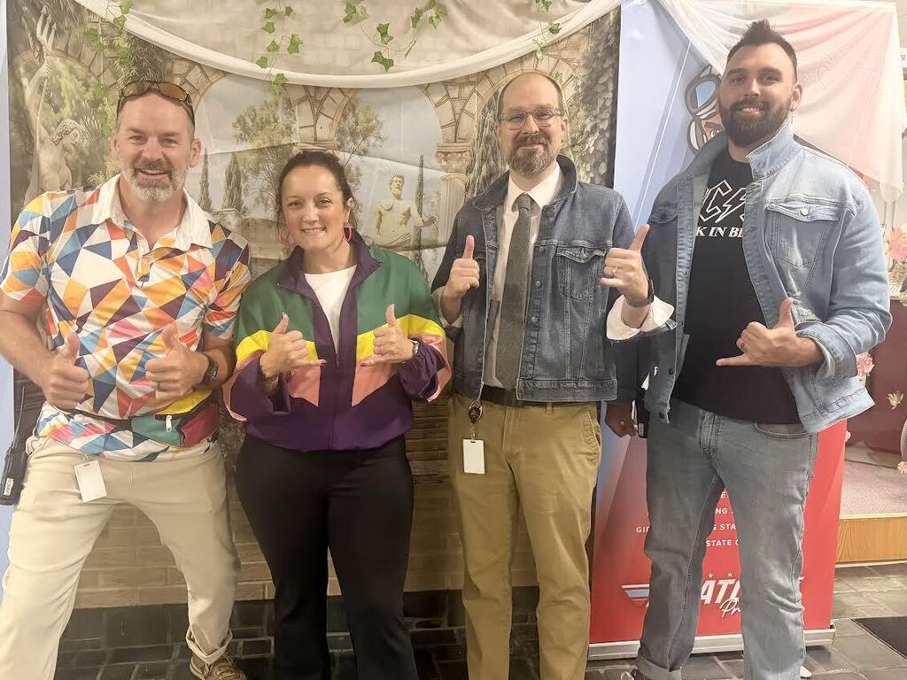 Staff members dressed in bright colors and 80s themed outfits