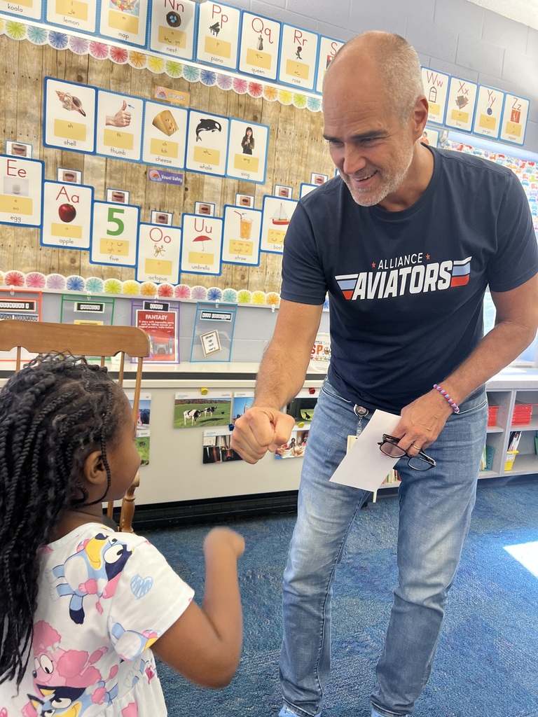 Mr. Jackson gives a child a fist bump while smiling