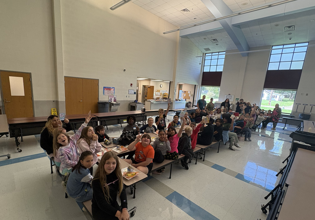 students sit together and talk at a lunch table