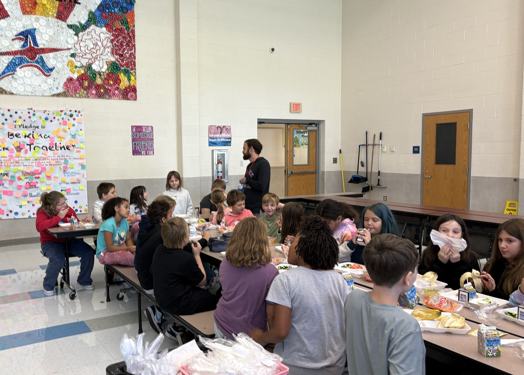 Students sit together and talk at a lunch table