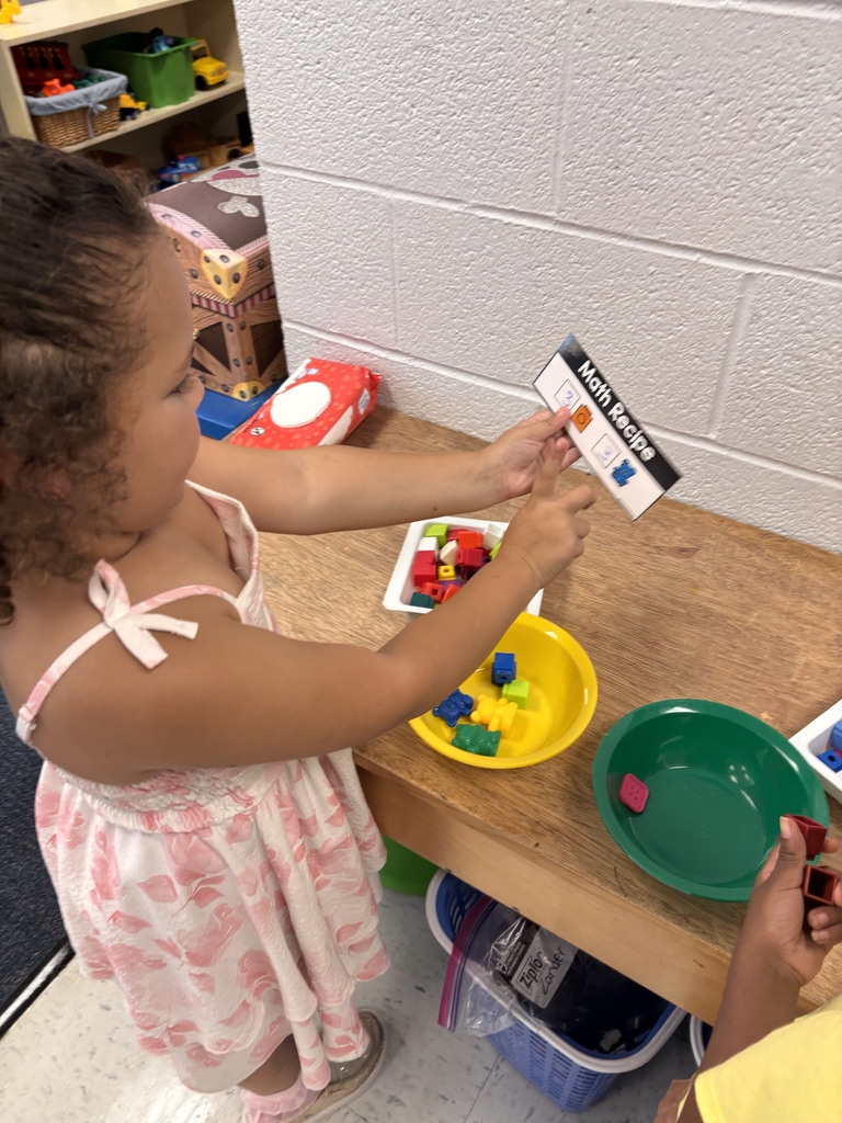Students are following their recipe cards to make math soup with their ingredients