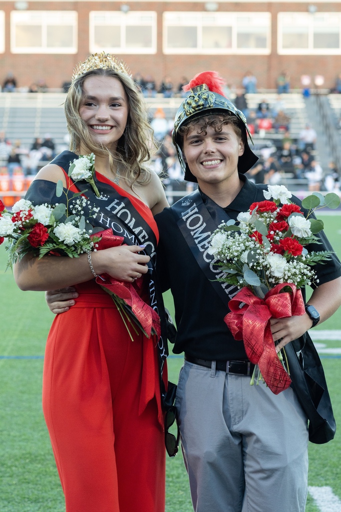 Lilliana White and Grady Duchon pose for a picture on the football field after being crowned homecoming royalty