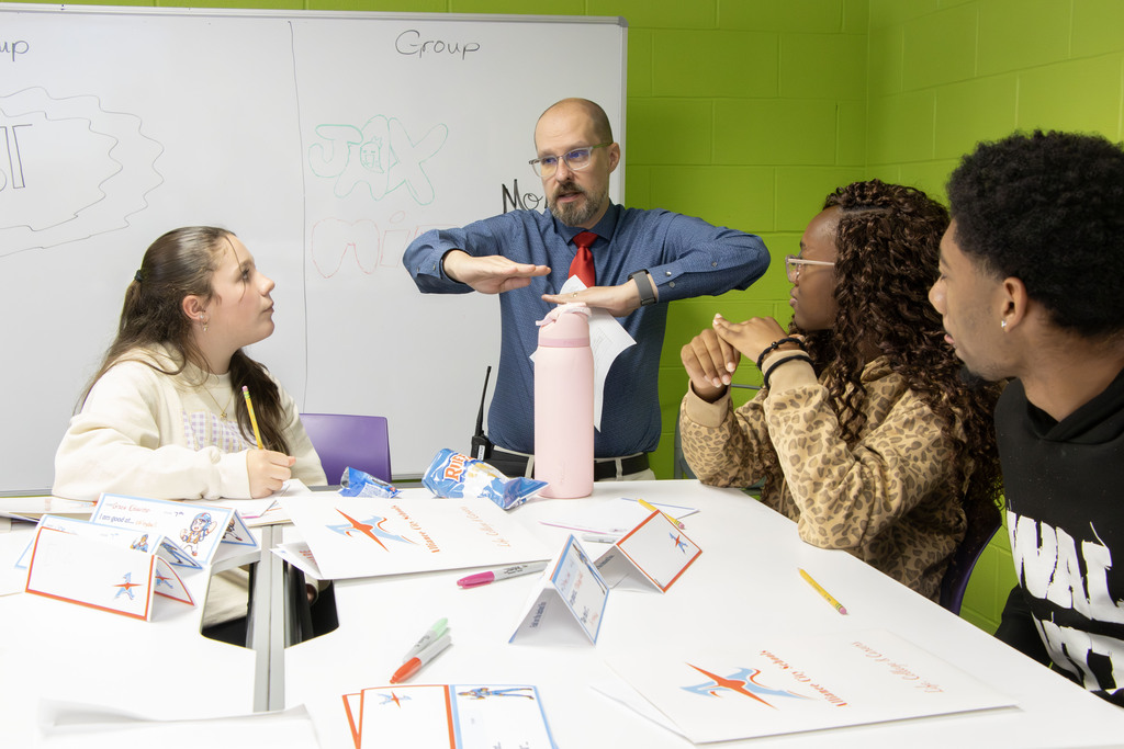 Mr. Fontaine speaks to a group of three students