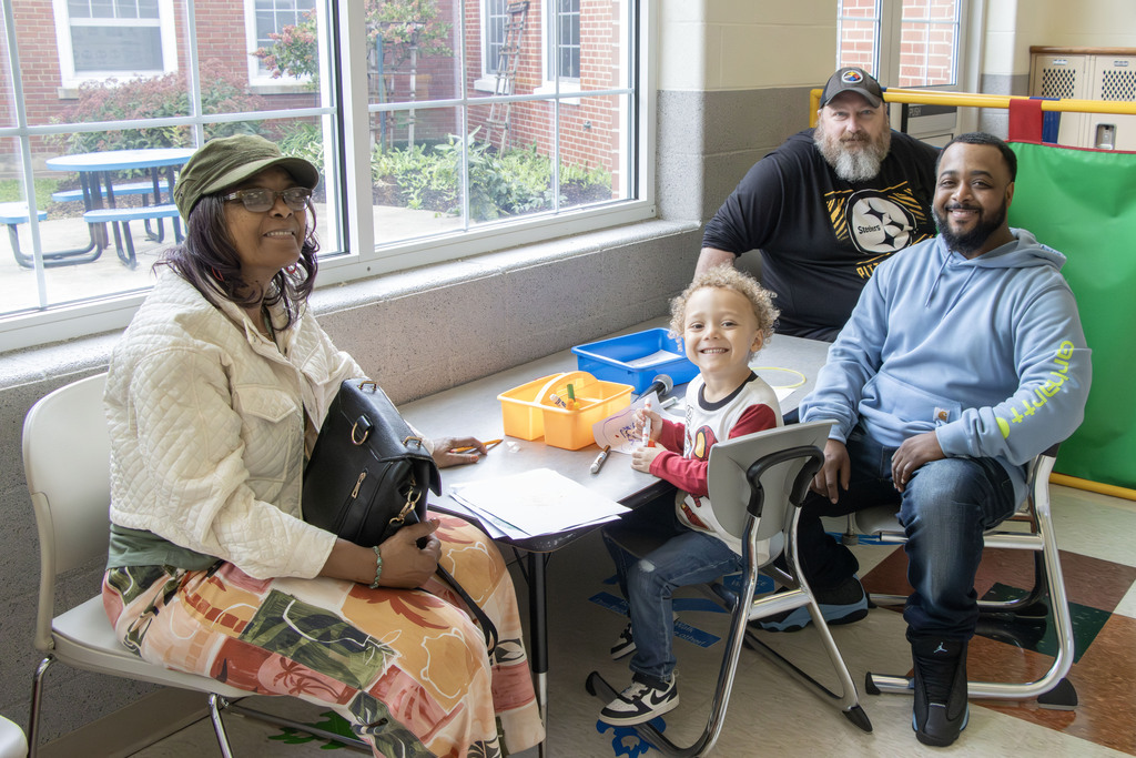 three grandparents sit at a table with their grandson