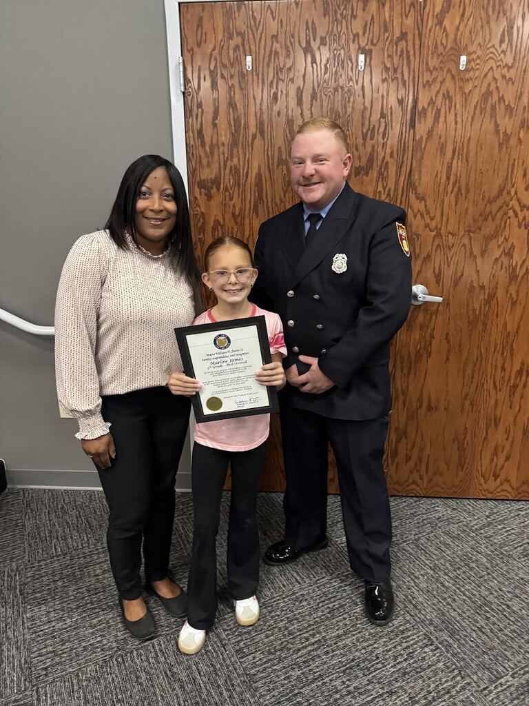 Marlow poses for a picture with Alliance Intermediate School Assistant Principal Erica Jackson and Alliance Firefighter Will Kinser