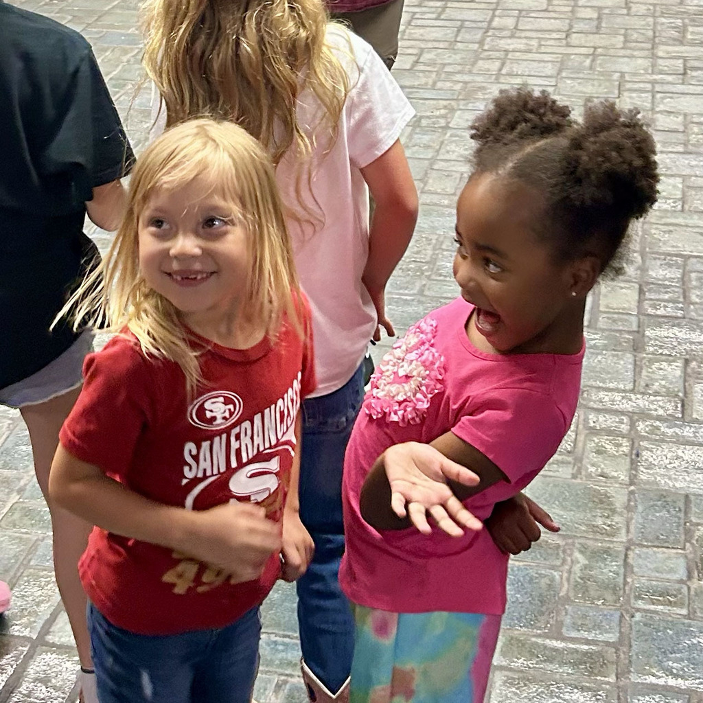 Two students smile while talking to each other