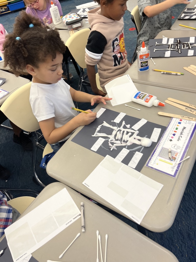 A student writes on labels to label the parts of the body