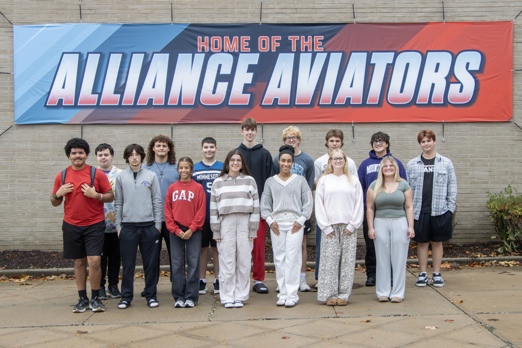 Group photo of all the students recognized in front of a large banner that says "Home of the Alliance Aviators"