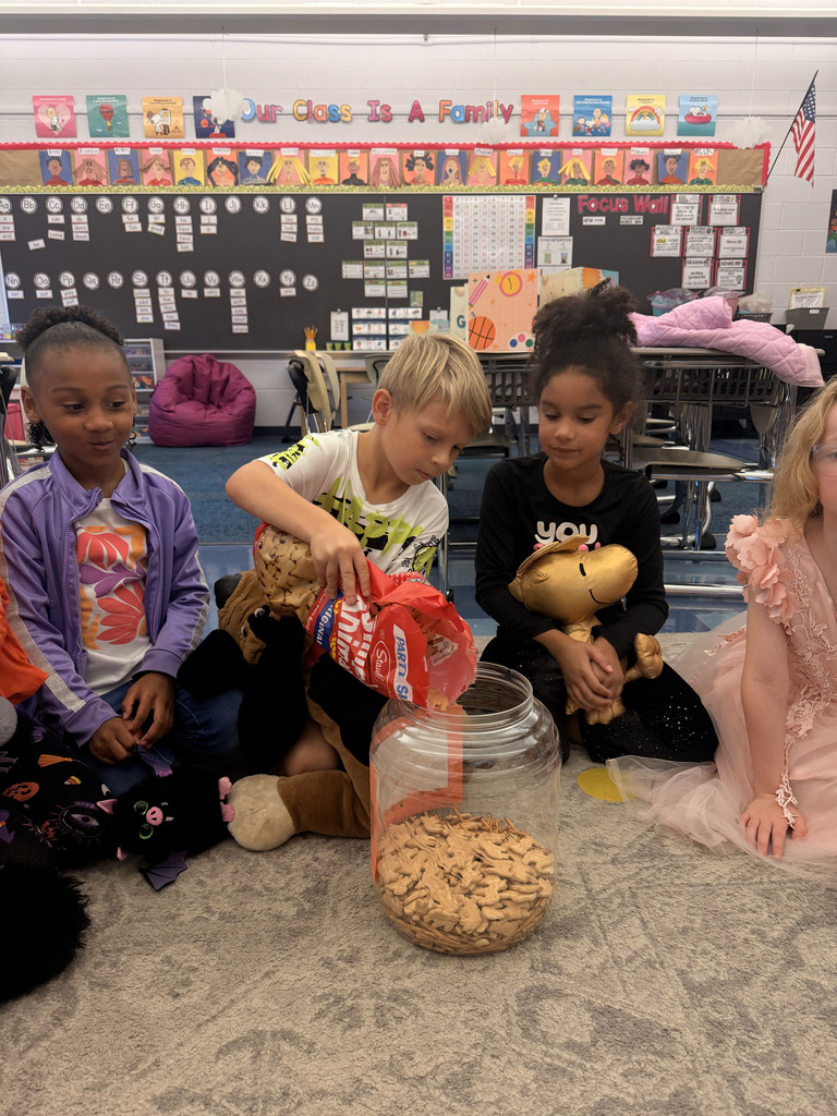 A student pours treats in a container while two other students watch.