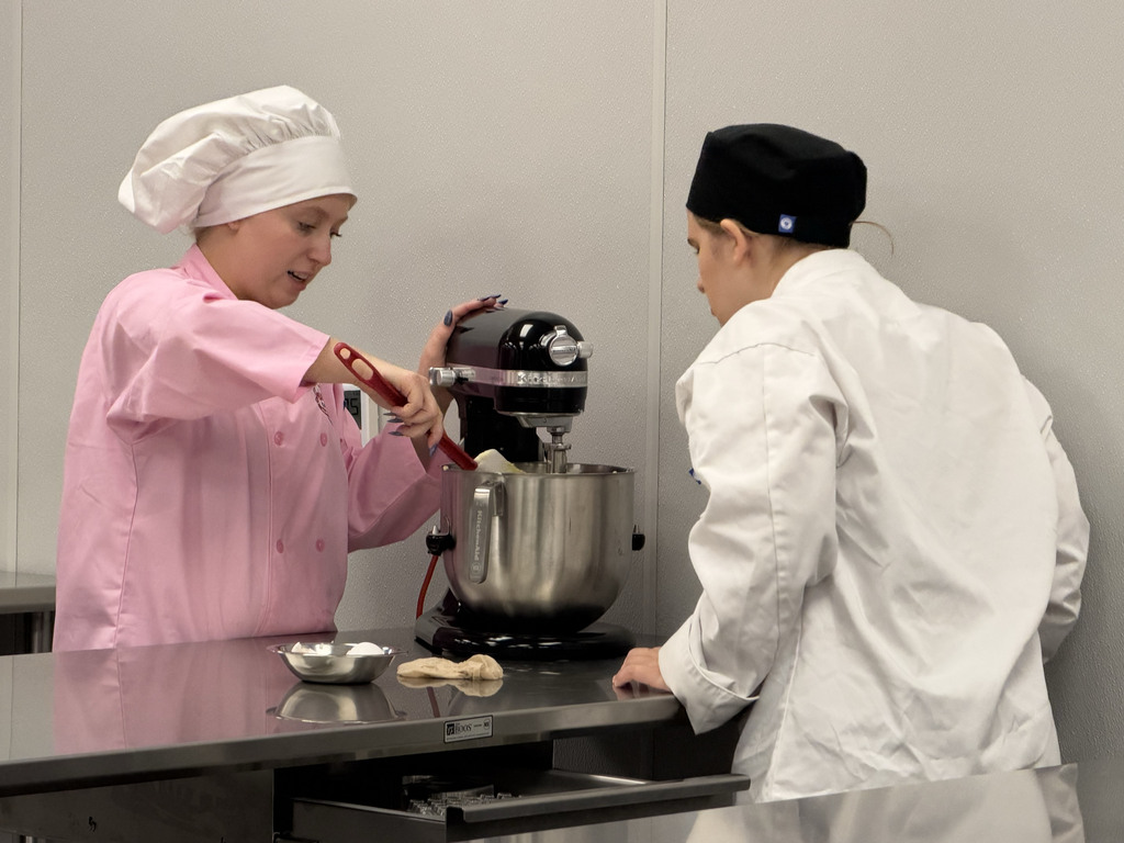 two students make dough using a stand mixer