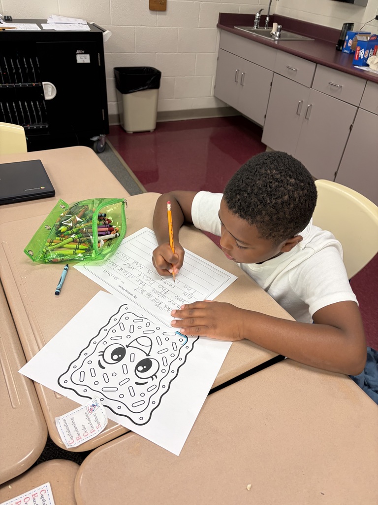 A student writes on a piece of paper with a black and white coloring of a pop tart on the table infront of him