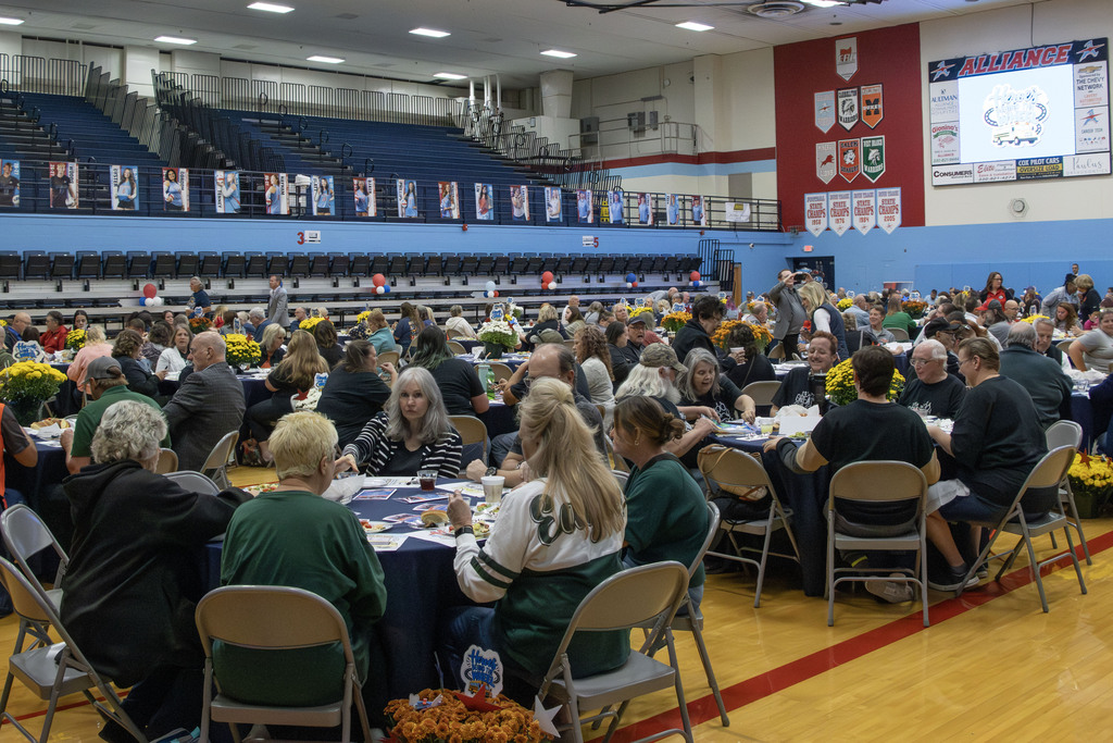 A picture of the Alliance High School gym full of people sitting at tables eating