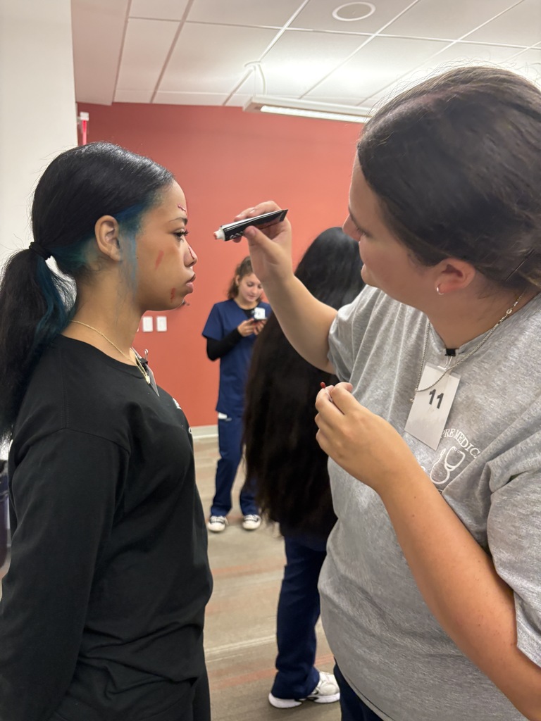 An Alliance Student stands still while a KSU Stark student looks her over.