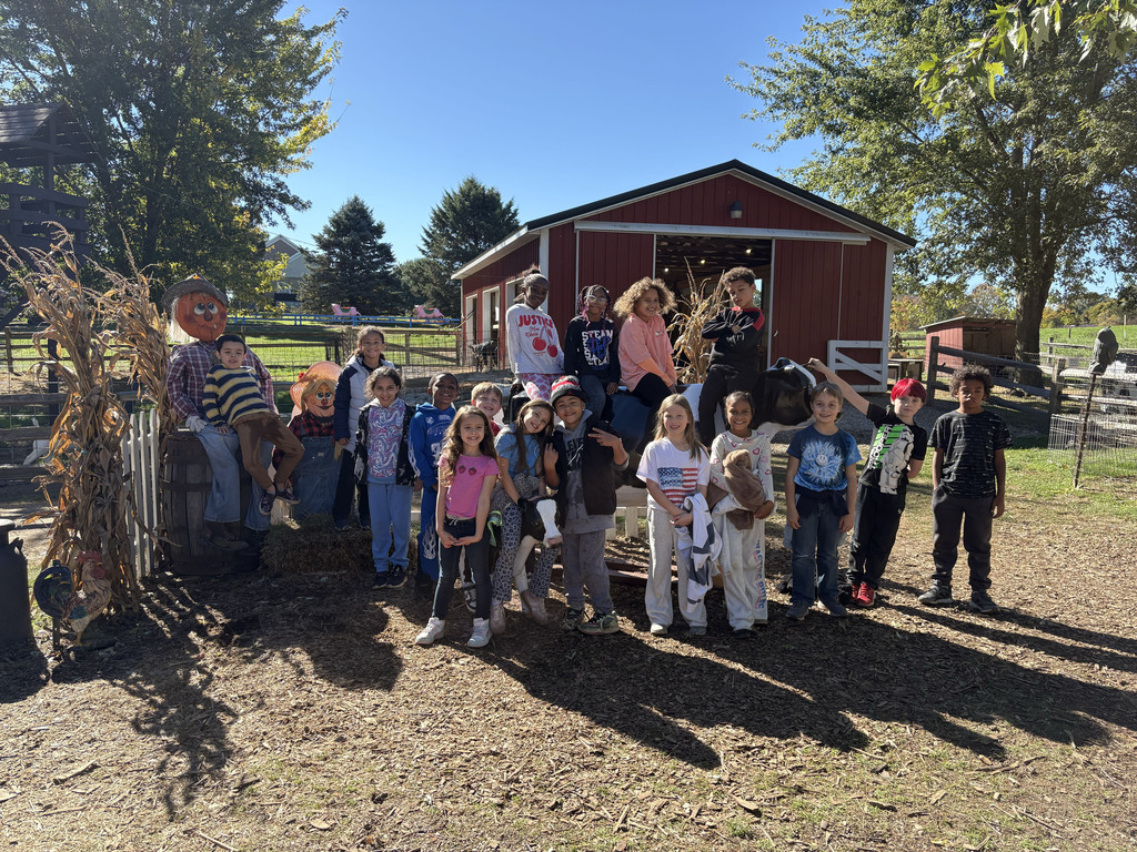Marti Alazaus' class pose for a picture in front of a small red barn