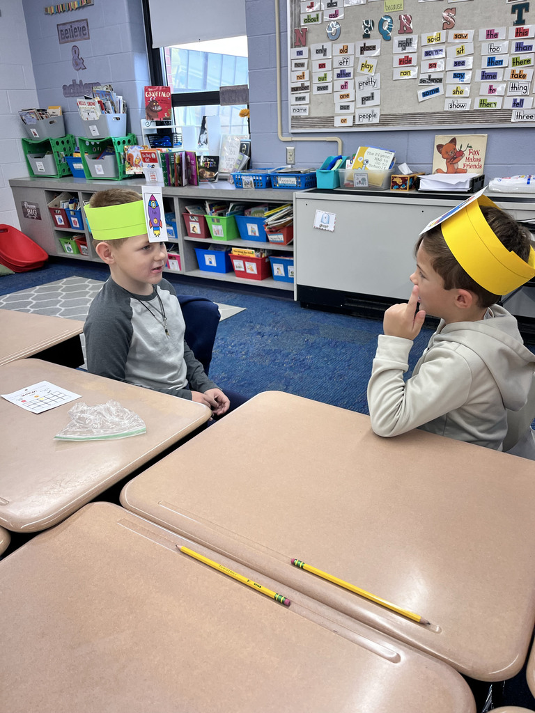 Two students look at each other and guess the nouns on their headbands