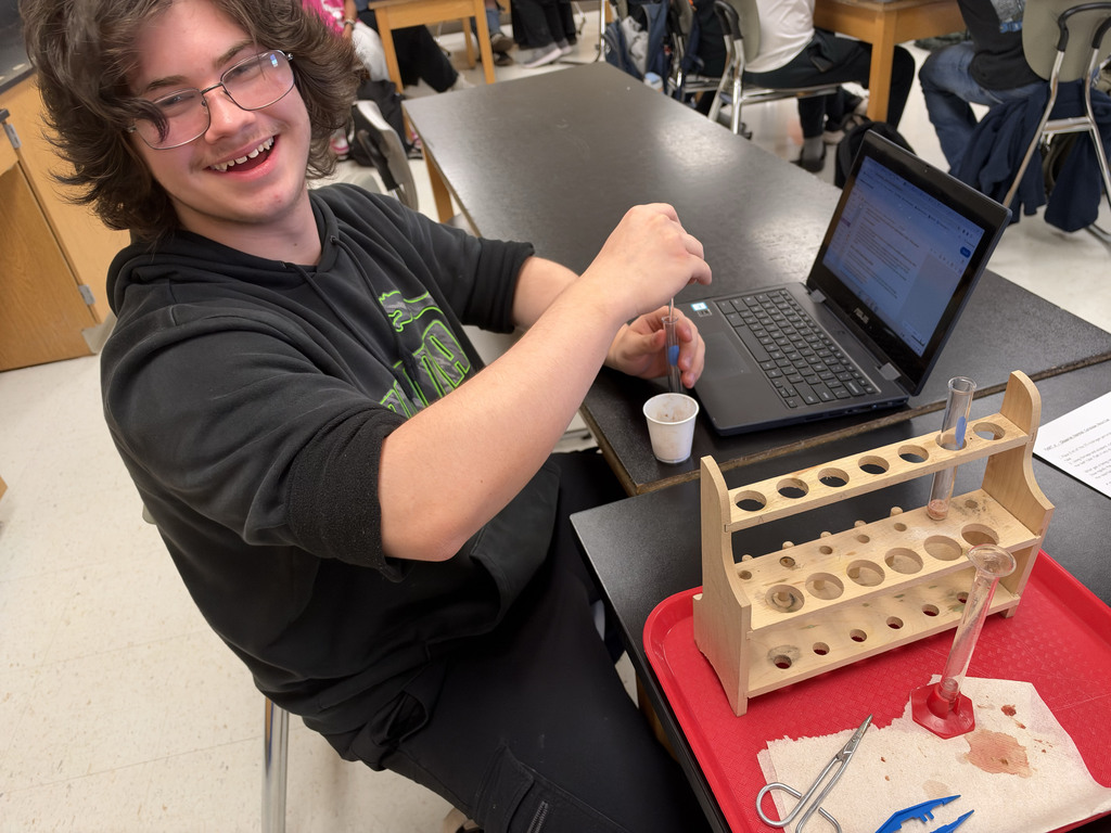 A student smiles while taking part in the science lab