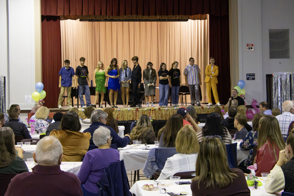 The cast of the show stands on stage while the audience watches from their seats
